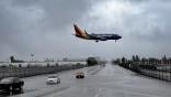 Southwest aircraft flies over a flooded road