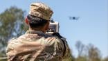 soldier pointing device at drone in distance