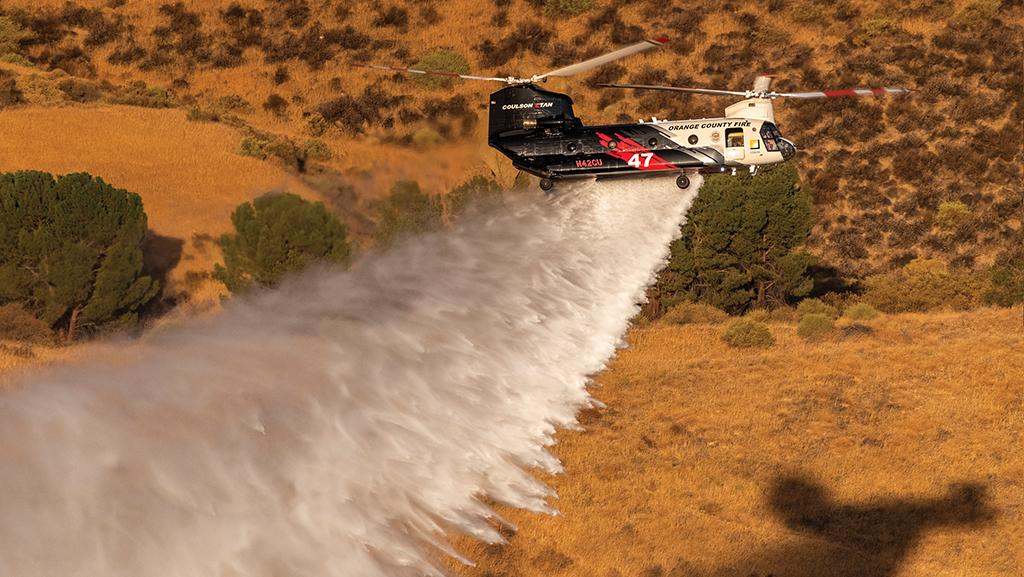 CH-47 Chinook dropping water over forested area