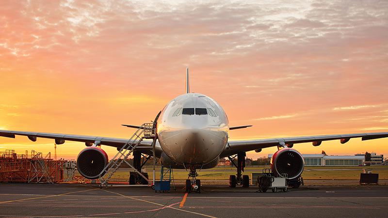 aircraft from the front with maintenance equipment and sunrise in background